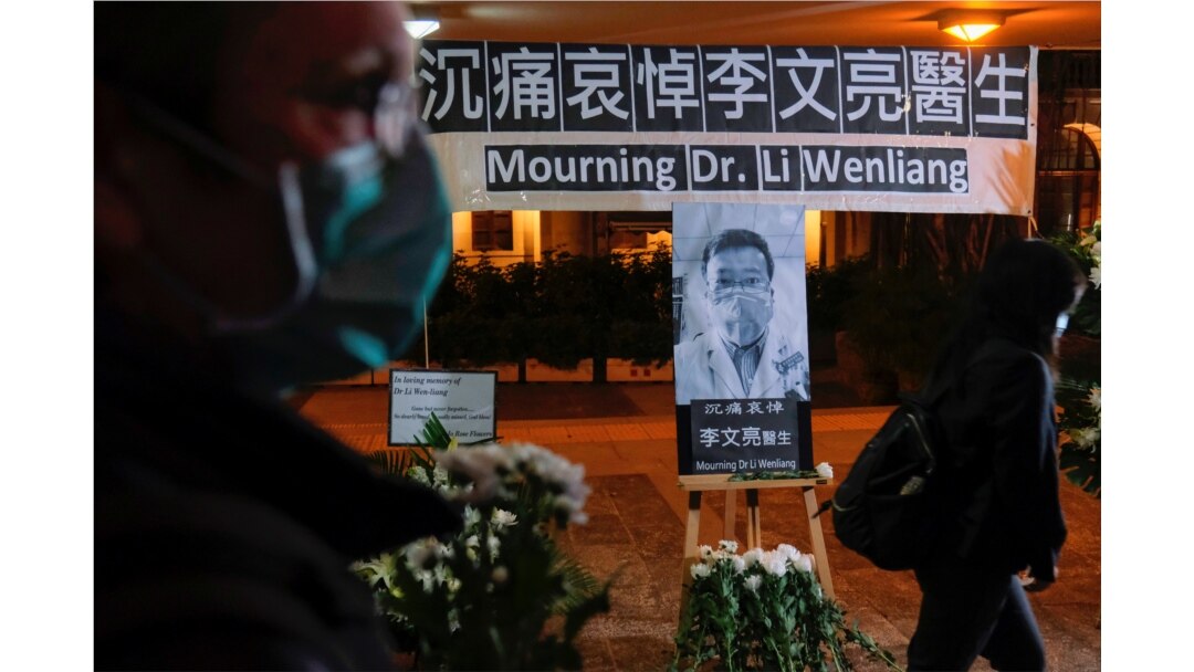 People wearing masks attend a vigil for the late Li Wenliang, an ophthalmologist who died of coronavirus at a hospital in Wuhan, in Hong Kong, Feb. 7, 2020.