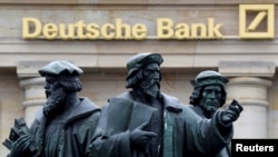  A statue stands next to the logo of Germany's Deutsche Bank in Frankfurt, Germany, Sept. 30, 2016.