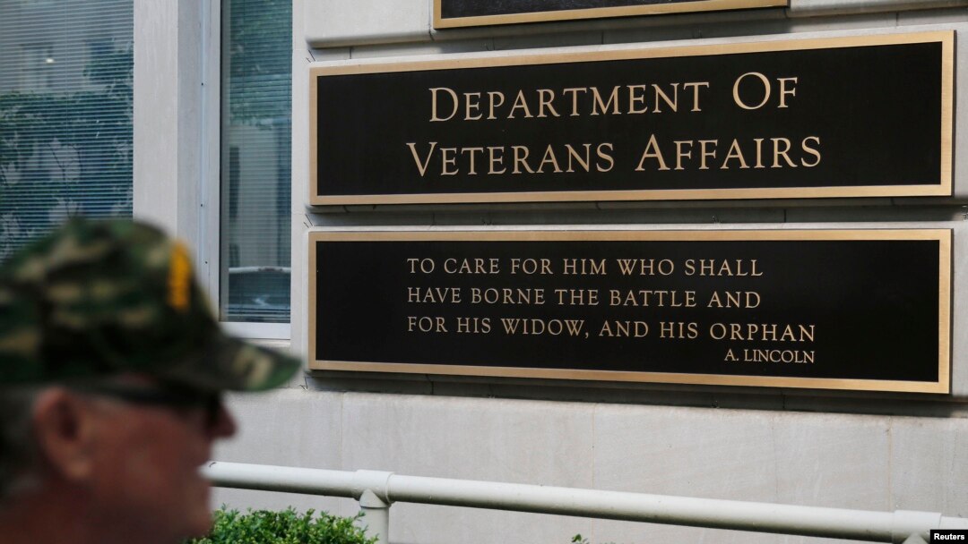 FILE - A man walks by the Department of Veteran Affairs building in Washington, May 23, 2014.