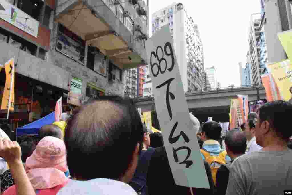 遊行人士手持要求特首梁振英下台的標語(美國之音 湯惠芸攝)