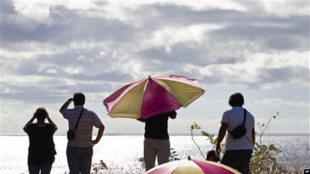 People look out to sea from a hill top after an alert of tsunami was launched in Hanga Roa, Easter Island, Chile, March 11, 2011