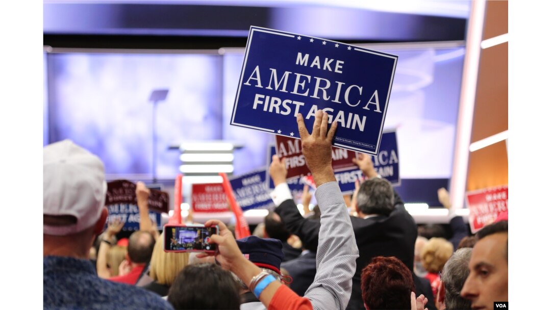 FILE - A delegate holds a "Make America First Again" sign at the Republican National Convention, July 20, 2016 (A. Shaker/VOA). So far, there's been no major revolt from supporters of President Donald Trump, despite their expectation he would be an agent of disruption.