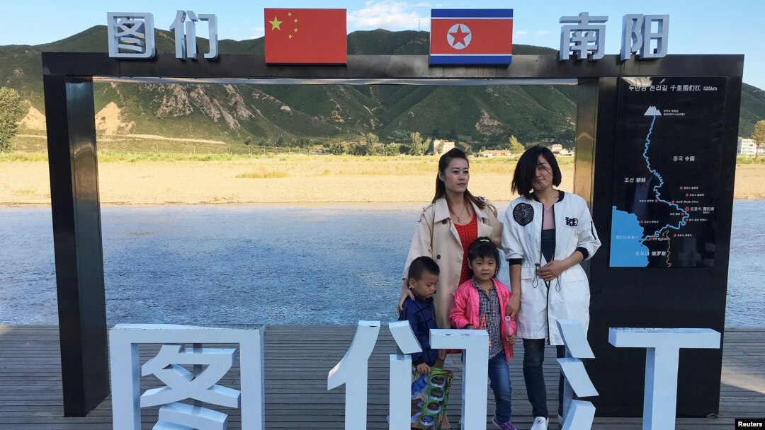 Tourists pose at the border with North Korea in Tumen, China, Aug. 30, 2017. China reported seven months of falling imports from North Korea.