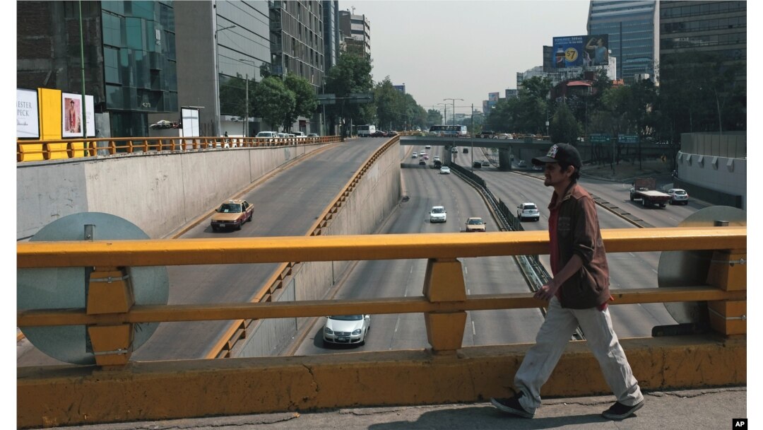 A man walks over what would usually be a very busy thoroughfare in Mexico City, April 6, 2016. City authorities barred millions of vehicles from the streets due to a pollution alert.