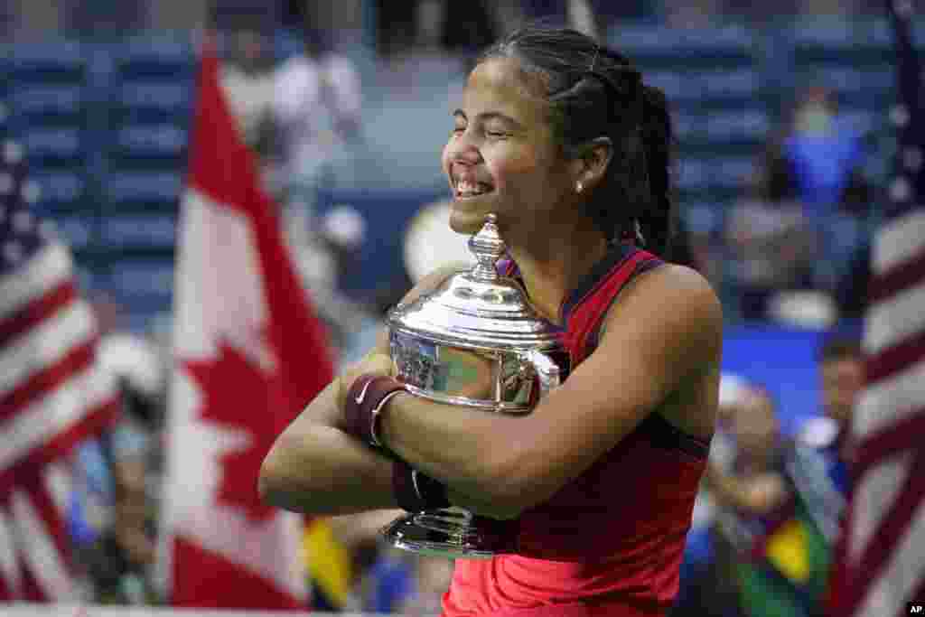 Emma Raducanu of Britain hugs the U.S. Open championship trophy after defeating Leylah Fernandez of Canada during the women's singles final of the U.S. Open tennis championships, Sept. 11, 2021, in New York.