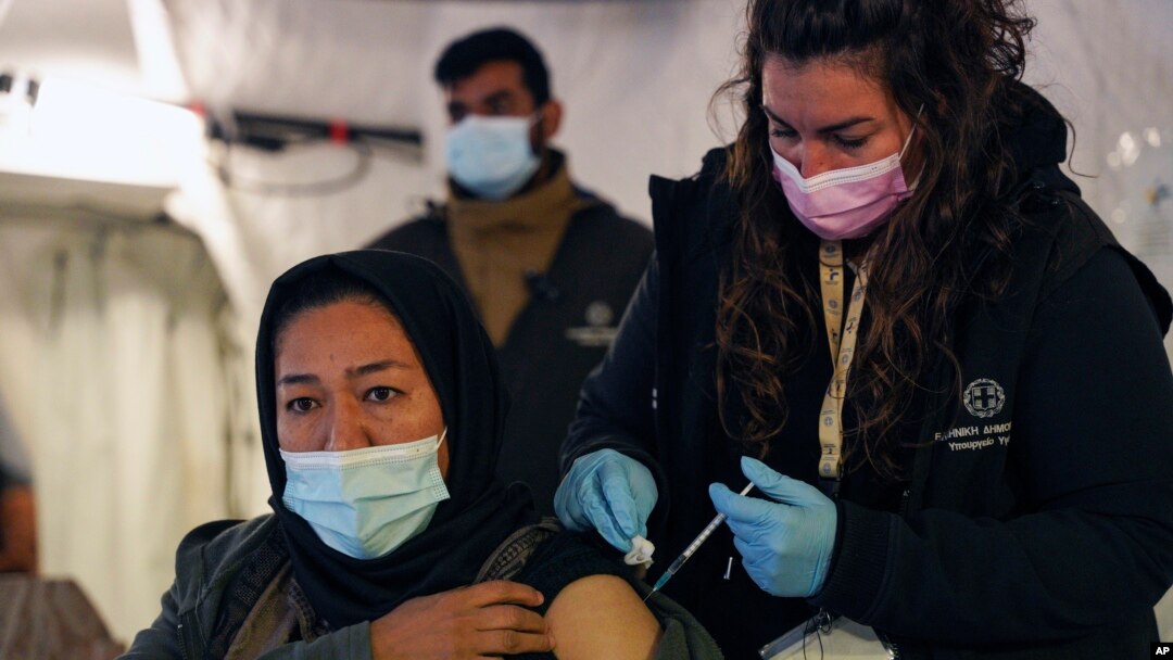 A migrant receives a booster Johnson and Johnson vaccine against COVID-19 at Karatepe refugee camp, on the northeastern Aegean island of Lesbos, Greece, Dec. 15, 2021.