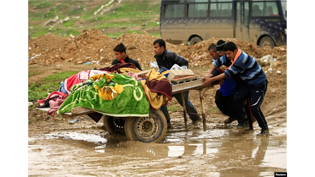 Relatives carry the bodies of civilians killed in air strikes during a battle between Iraqi forces and Islamic State militants, in Mosul, Iraq, March 17, 2017.