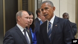 Russian President Vladimir Putin, left, listens to U.S. President Barack Obama in Hangzhou in eastern China's Zhejiang province, Sept. 5, 2016.