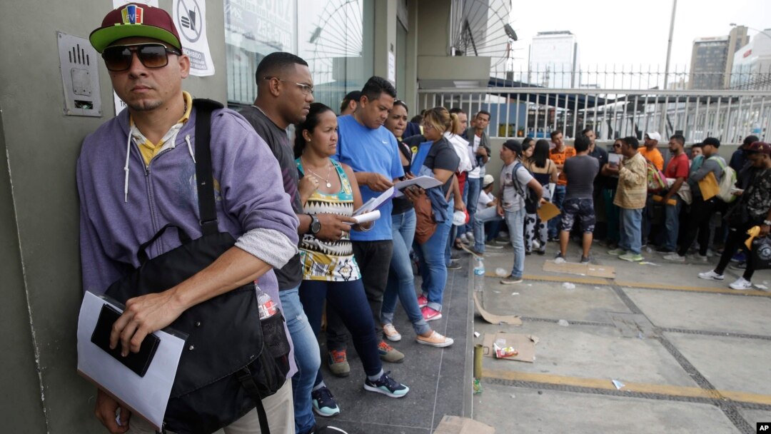 FILE - Venezuelan citizens stand in a line outside the Foreign Ministry office in Lima, Peru, Jan. 23, 2018.