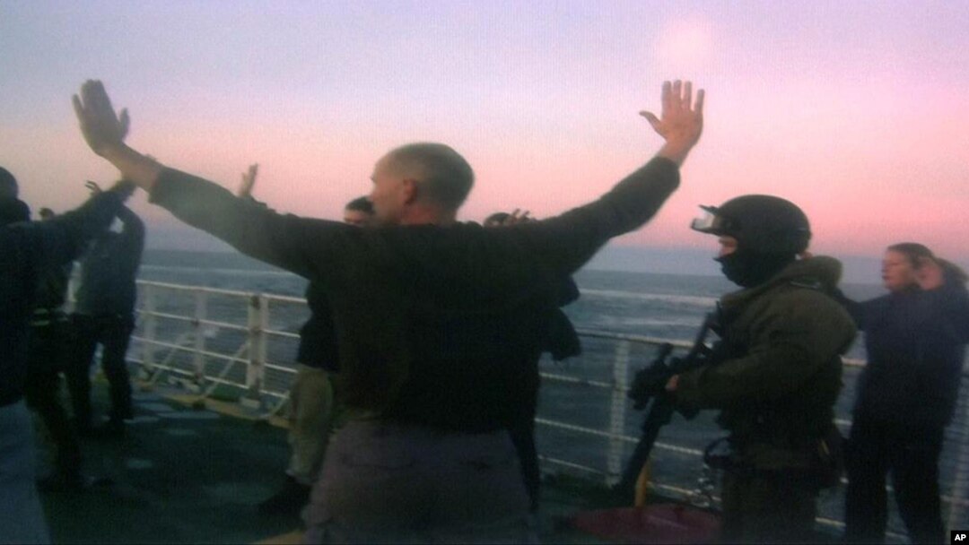 In this image provided by Greenpeace, Oct. 2, 2013, Russian Coast Guards seize the Greenpeace ship the Arctic Sunrise and detain the crew following a protest by Greenpeace activists at a Russian oil platform in the Pechora Sea, off the coast of Russia, Sept. 19, 2013. 