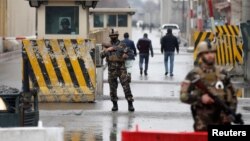 Afghan security forces keep watch at a checkpoint near the site of a suicide attack in Kabul, Afghanistan, Feb. 24, 2018. 