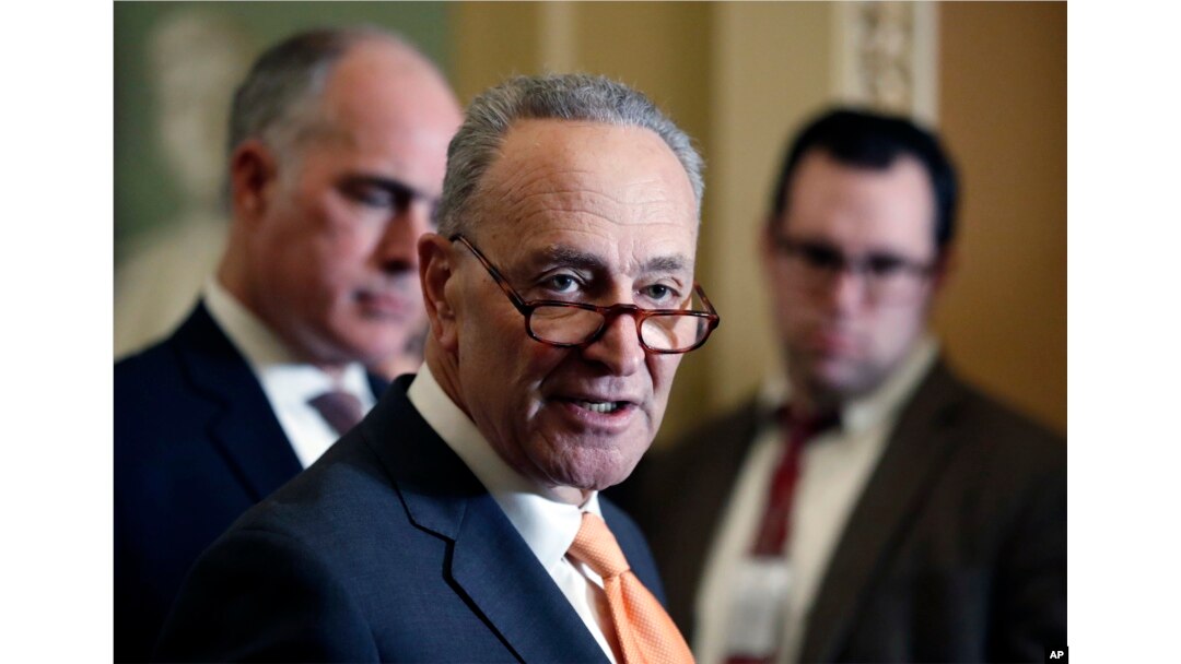 Senate Minority Leader Chuck Schumer of N.Y., center, accompanied by Sen. Bob Casey, D-Pa., at left, speaks on Capitol Hill, Feb. 6, 2018 in Washington.