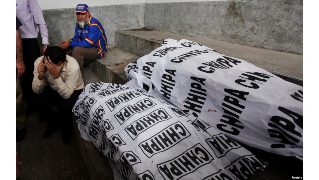 The relative of a female polio vaccination worker, who was killed by unidentified gunmen, talks on the phone while sitting near her body at a morgue in the Jinnah Post Graduate Medical Center in Karachi, Pakistan, Jan. 21, 2014.