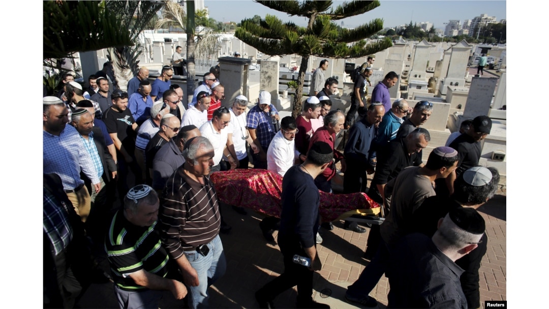 The body of Reuven Aviram, 51, one of two people killed Nov. 19 in a Palestinian stabbing attack in Tel Aviv, is carried by friends and relatives during his funeral in Ramle, Israel, Nov. 20, 2015.