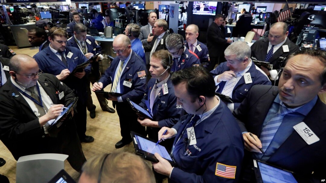 Traders gather at a post on the floor of the New York Stock Exchange, Feb. 26, 2016. 