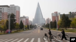 戴著口罩推車從北韓首都平壤柳京飯店前的一條路上走過。(2020年4月28日)