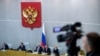 FILE - A video journalist shoots from the balcony as Russian lawmakers prepare to vote in the State Duma, the Lower House of the Russian Parliament in Moscow, Russia, Dec. 6, 2017. 