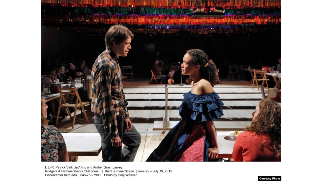 Patrick Vaill as Jud Fry and Amber Gray as Laurey perform in Gideon Lester's production of "Oklahoma!," which placing the audience close to the action — at long tables on all four sides of the staging area.
