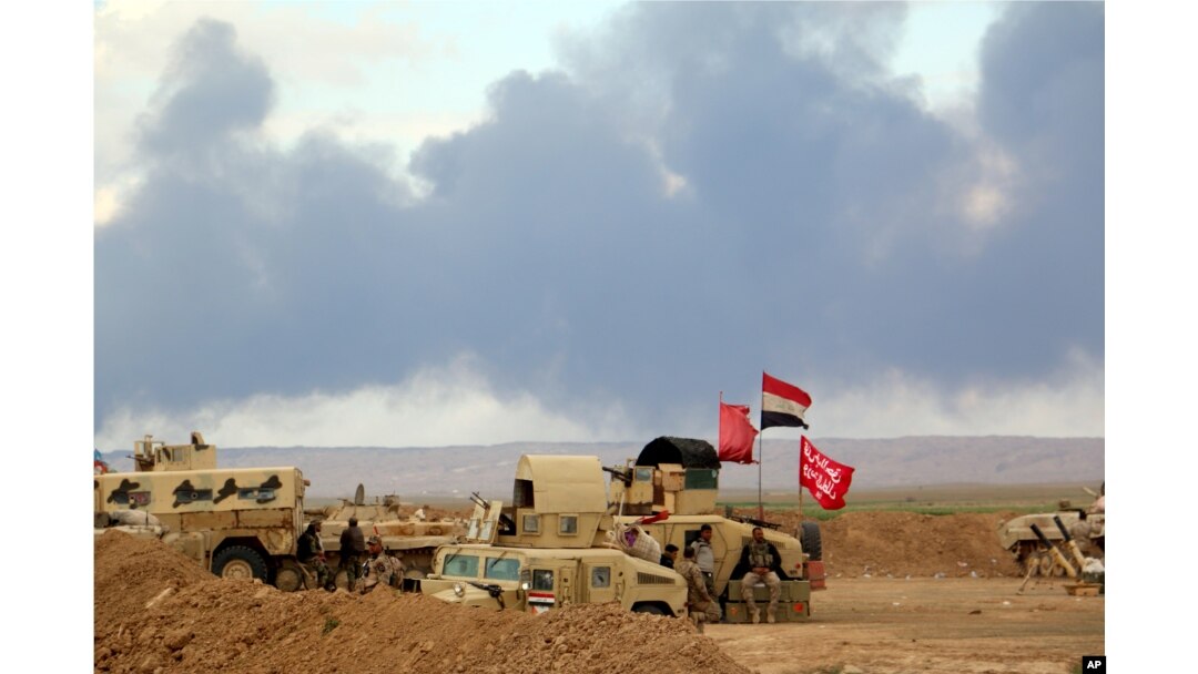 FILE - Smoke rises as the Iraqi army, supported by Iranian-backed Shiite militias and Sunni tribes, battles Islamic State extremists outside Tikrit, 80 miles (130 kilometers) north of Baghdad, Iraq, March 4, 2015.