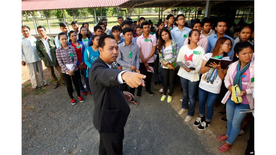 FILE - Cambodian court officer Neth Pheaktra guides students outside the court hall before appeal hearings against two former Khmer Rouge senior leaders, Khieu Samphan and Nuon Chea, at the U.N.-backed war crimes tribunal in Phnom Penh, Cambodia, July 2015.