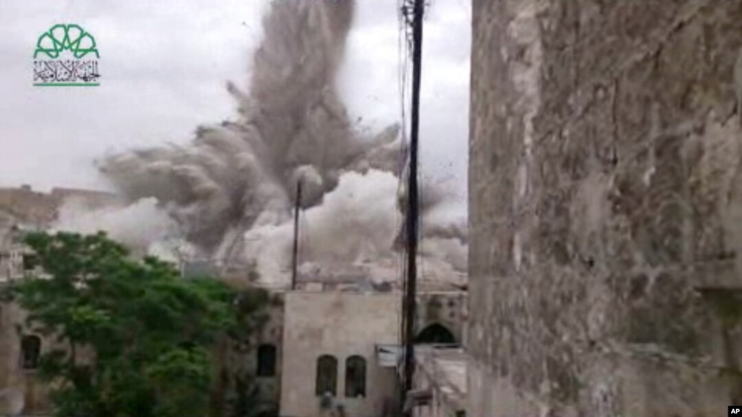 This image made from amateur video posted by Shaam News Network (SNN), an anti-Bashar Assad activist group, shows an explosion that destroyed the Carlton Hotel in Aleppo, Syria, May 8, 2014.
