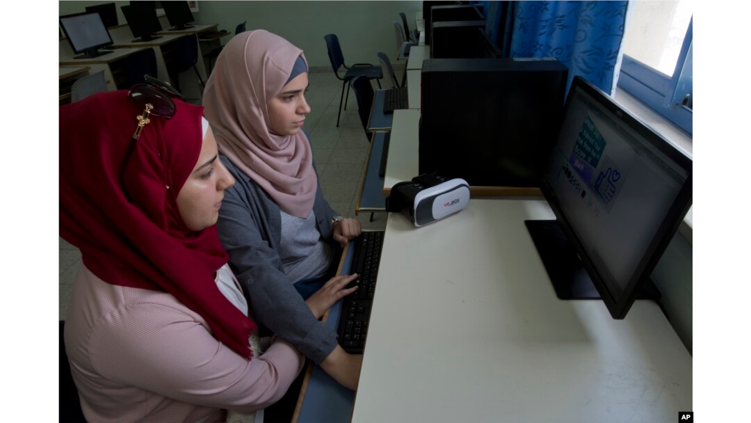 Wassan al-Sayyed,17, right, and Massa Halawa, 16, run the team's virtual reality game "Be a Fire Fighter" in the West Bank city of Nablus, Aug. 2, 2018. Four Palestinian high school friends are heading to California this week to pitch their mobile app about fire prevention to Silicon Valley's tech leaders.