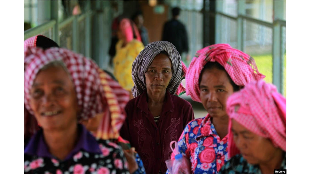 FILE - Women arrive at the entrance gate to the Extraordinary Chambers in the Courts of Cambodia (ECCC) for the trial hearing on evidences of forced marriage and rape during the Khmer Rouge regime, on the outskirts of Phnom Penh, Cambodia, Aug. 23, 2016.