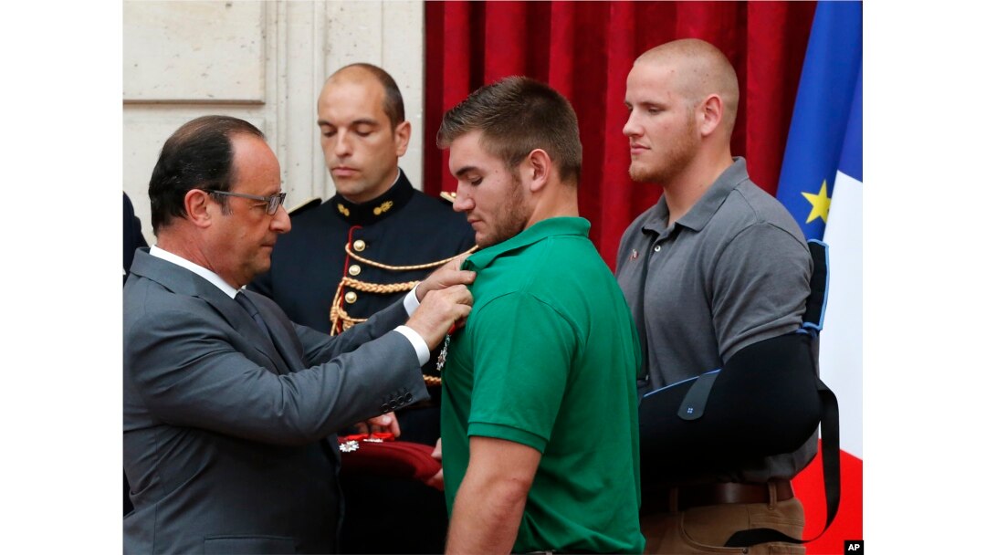 French President Francois Hollande, left, awards with the Legion of Honor Alek Skarlatos a U.S. National Guardsman from Roseburg, Oregon, while U.S. Airman Spencer Stone, right, looks on at the Elysee Palace, Monday Aug.24, 2015 in Paris, France.