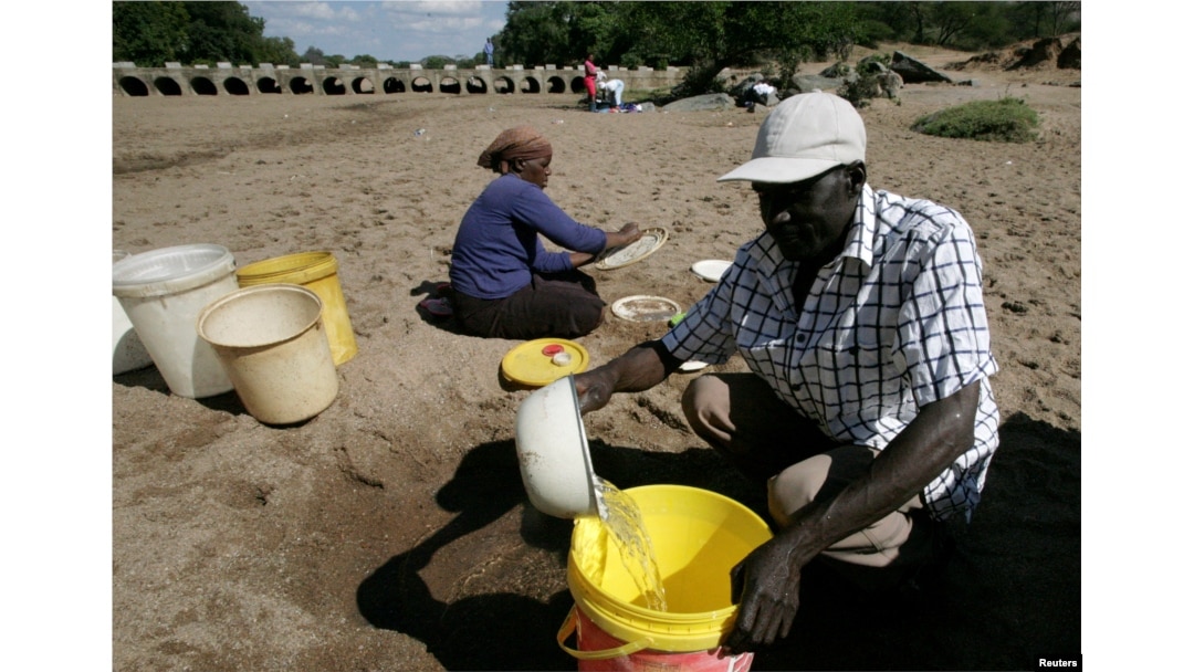 FILE - Villagers collect water from a dry riverbed in drought-hit Masvingo, Zimbabwe, June 2, 2016.