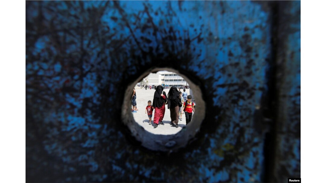 Refugee schoolchildren walk with their mothers on the first day of the new school year at one of the UNRWA schools at a Palestinian refugee camp al Wehdat, in Amman, Jordan.
