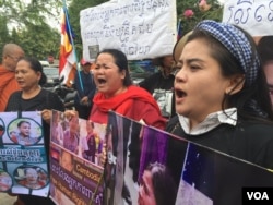 FILE - Bov Sophear and Song Sreyleap, land rights activists in Boeung Kak community, shouted for justice before the Supreme Court, Feb. 27, 2017.