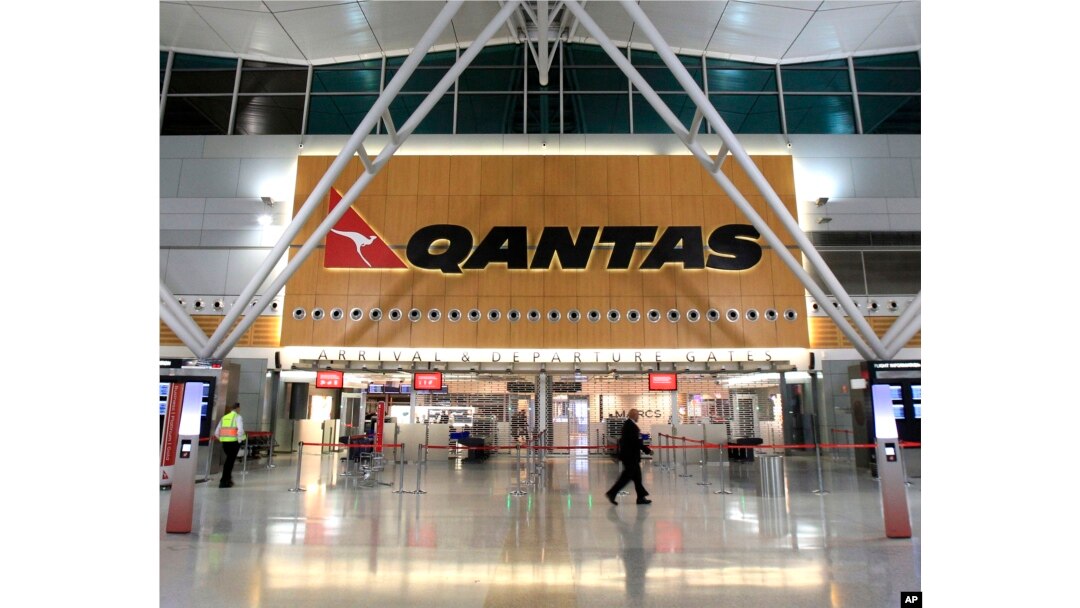 FILE - Two security workers walk through a near empty Qantas domestic terminal at Sydney Airport in Sydney, Oct. 29, 2011.