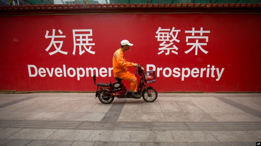 資料照片：資料照片：北京中心地帶一面牆上的中英雙語標語顯示“發展”和“繁榮”。 (2015年7月15日)