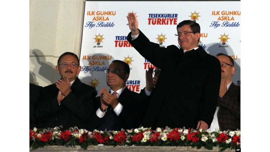 Turkish Prime Minister Ahmet Davutoglu salutes supporters gathered outside the ruling Justice and Development Party headquarters in Ankara, Turkey, Sunday, Nov. 1, 2015.