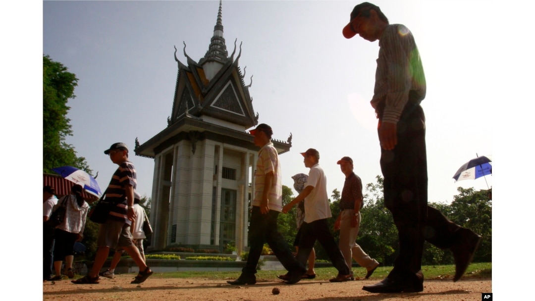 FILE - Foreign tourists walk through Choeung Ek stupa, which stores thousands of human bones and skulls of the Khmer Rouge's victims in the outskirt of Phnom Penh, Cambodia, June 25, 2011.