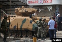FILE - People speak with Turkish soldiers in the center of Afrin, Syria March 24, 2018.