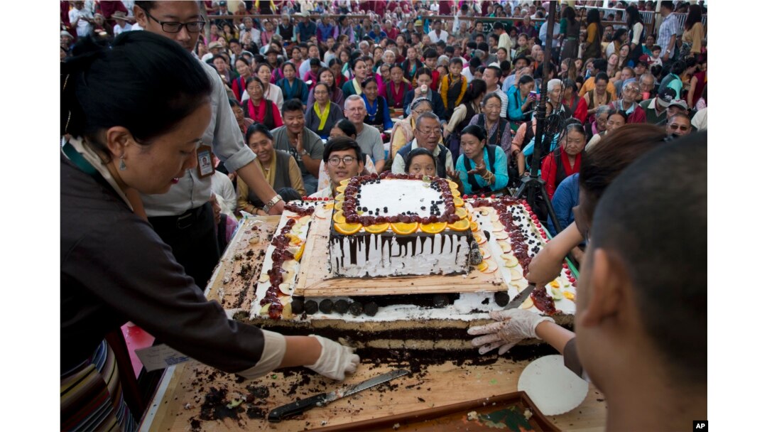 Exile Tibetans wait for a cake to be distributed as they mark the 82nd birthday of their spiritual leader the Dalai Lama in Dharmsala, India, July 6, 2017. In a public event attended by hundreds, Tibetans danced, distributed sweets and offered their respects in front of a portrait of their leader.
