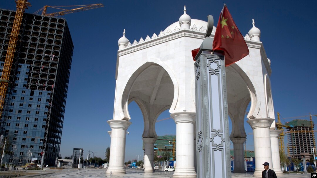 FILE - A man walks past a pavilion with Islamic architectural features in Yinchuan in northwestern China's Ningxia Hui autonomous region, Oct. 8, 2015.