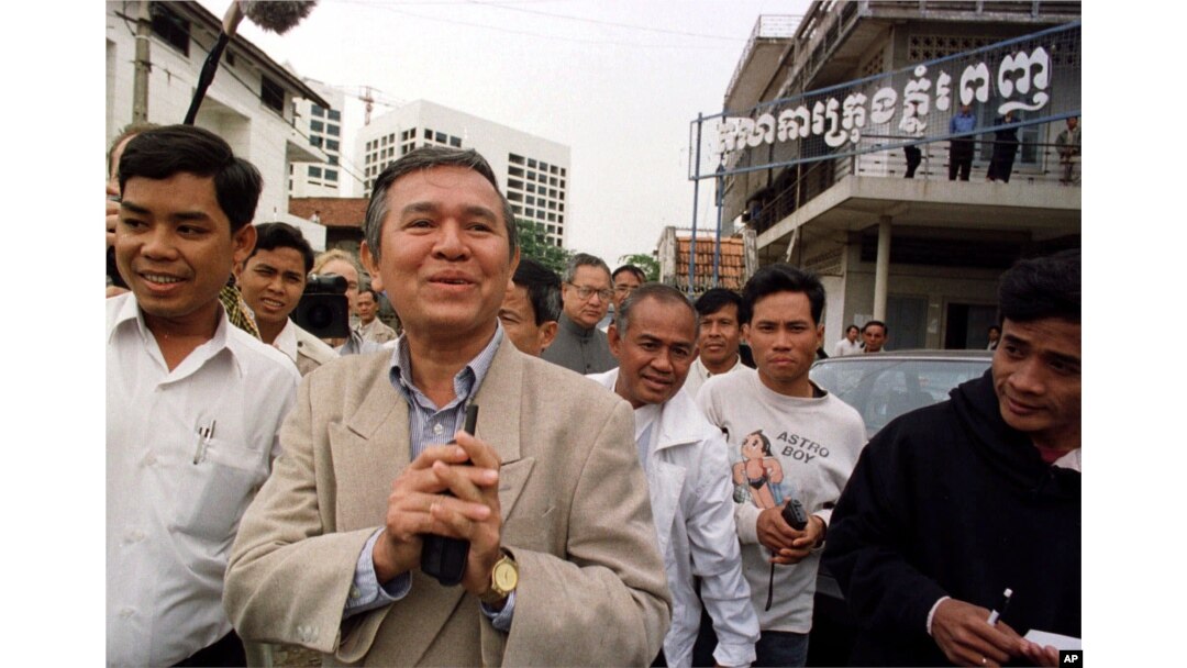 Kem Sokha, former chairman of the Cambodian parliament's human rights commission, center, greets the press as he leaves the Phnom Penh Municipal Court in Cambodia Tuesday, Dec. 15,1998.