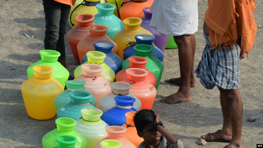 FILE - Indian residents line up with plastic containers to get drinking water from a tanker in the outskirts of Chennai, May 29, 2019.