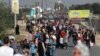 Palestinians walk down a road as they flee Gaza City and other parts of northern Gaza towards the southern areas on November 8, 2023 amid ongoing battles between Israel and the Palestinian Hamas movement. (Photo by MOHAMMED ABED / AFP)