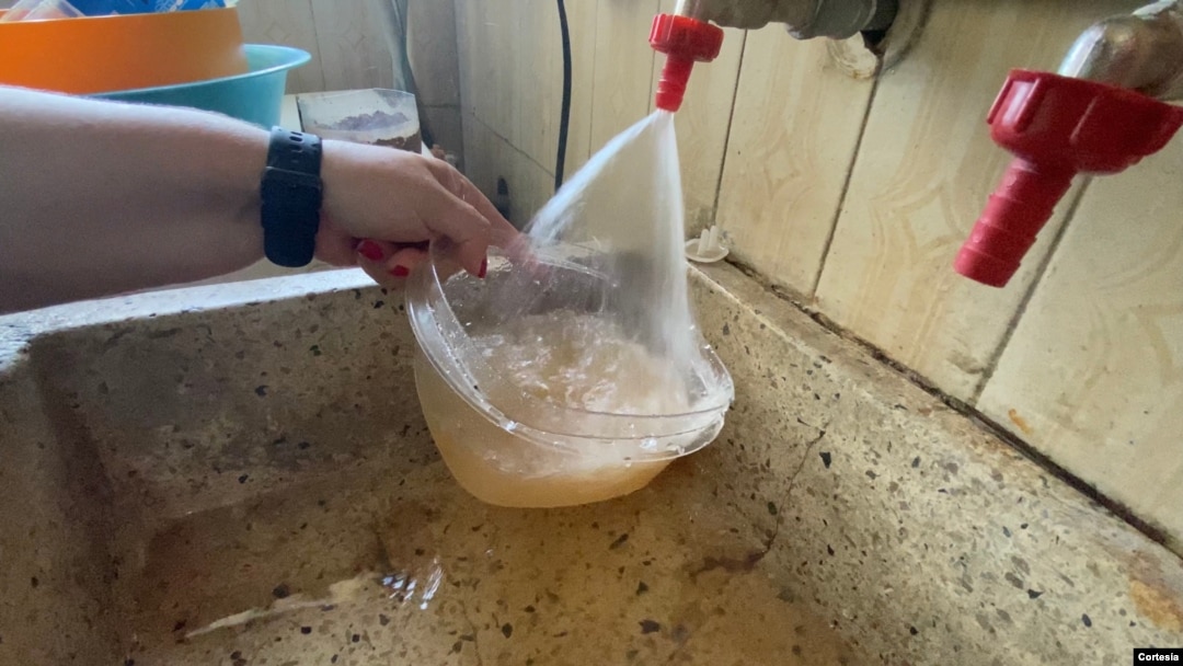 Una ciudadana agarra agua de un grifo de su casa en Maracaibo, estado Zulia, Venezuela. Junio, 2020. Foto: Gustavo Ocando - VOA.