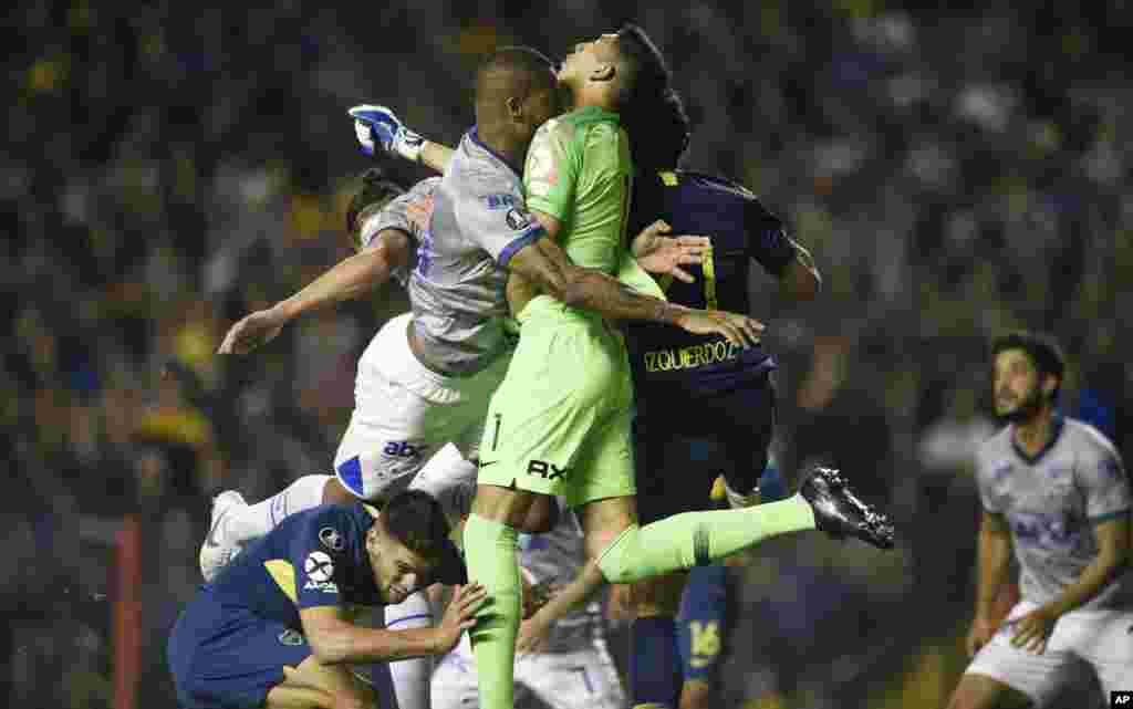 Dede of Brazil's Cruzeiro, left, and Esteban Andrada, goalkeeper of Argentina's Boca Juniors, clash during a Copa Libertadores quarterfinal soccer match in Buenos Aires, Argentina, Sept. 19, 2018.