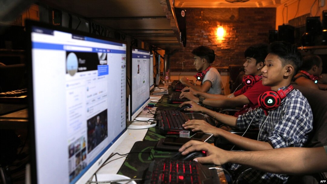 FILE - This picture taken on Dec. 18, 2018 shows Myanmar youths browsing their Facebook page at an internet shop in Yangon.