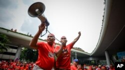 Pro-government 'red shirt' protestors shout slogans during a pro-government demonstration in Kuala Lumpur, Malaysia on Wednesday, Sept. 16, 2015.