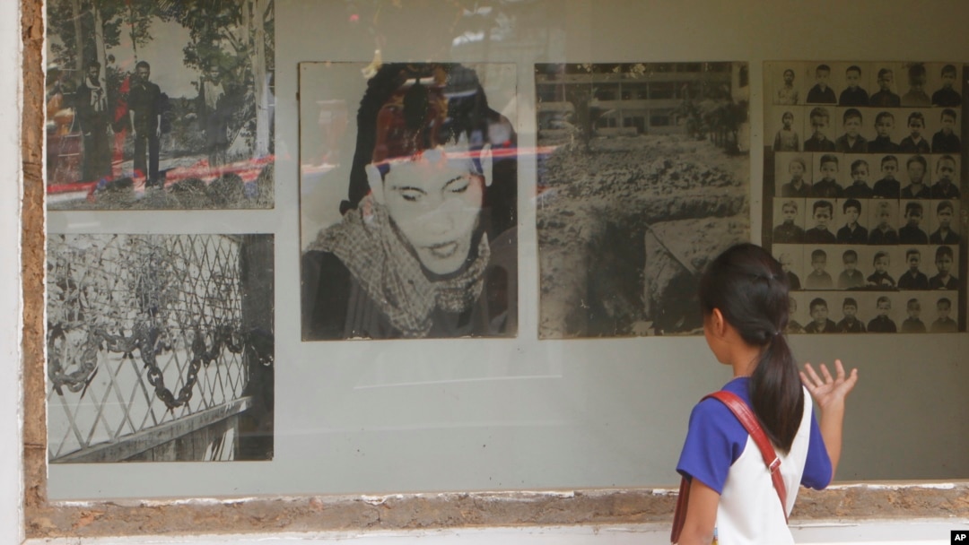 FILE - A Cambodian girl looks at images of Khmer Rouge victims at Tuol Sleng genocide museum, formerly the regime's notorious S-21 prison in Phnom Penh, Cambodia, March 26, 2015.