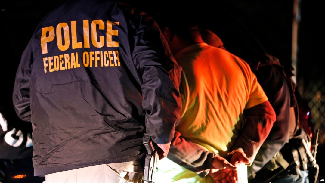 FILE - U.S. Immigration and Customs Enforcement agents surround and detain a person during a raid in Richmond, Va., Oct, 22, 2018.
