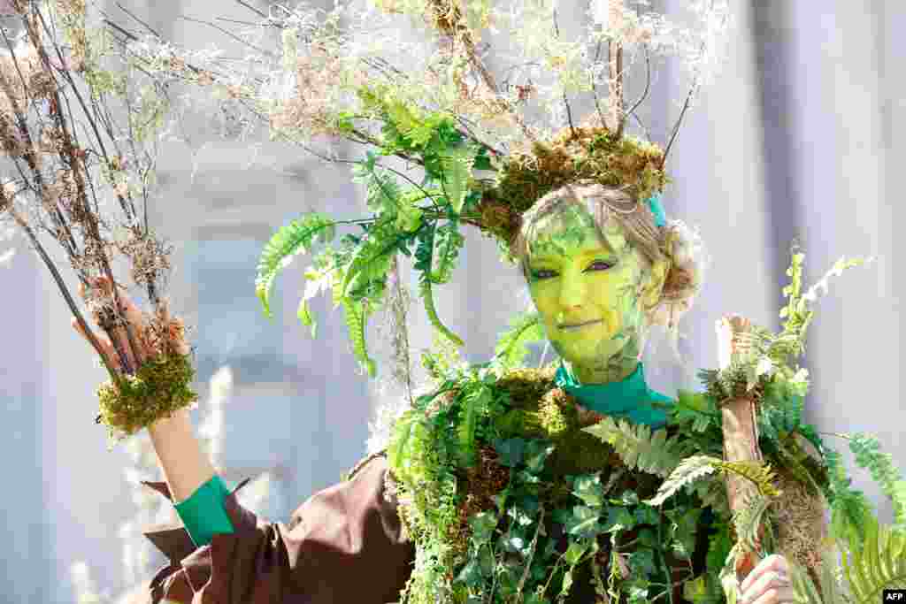A woman dressed as a tree with the group The Forgotten Solution, poses for a picture at Civic Center Plaza after marching at the 'Rise For Climate' global action in downtown San Francisco, California, Sept. 8, 2018.