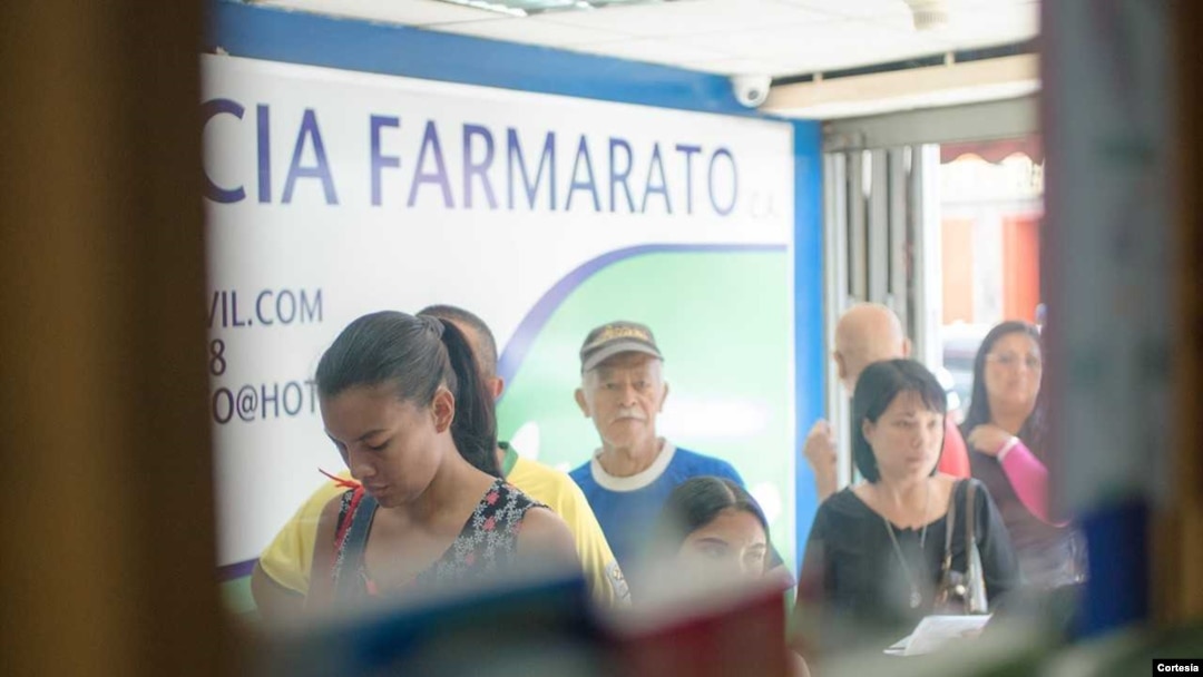 Personas hacen fila para comprar medicina en Farmarato, farmacia en el corazón de un populoso barrio al oeste de Caracas, Venezuela. Foto: Camilo Paparoni.