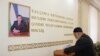 A man casts his ballot next to a portrait of Uzbekistan's President Shavkat Mirziyoyev during parliamentary election in Tashkent, Uzbekistan, Dec. 22, 2019. 